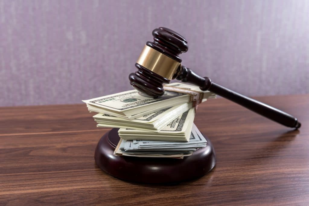 Judge gavel with dollars on wooden table