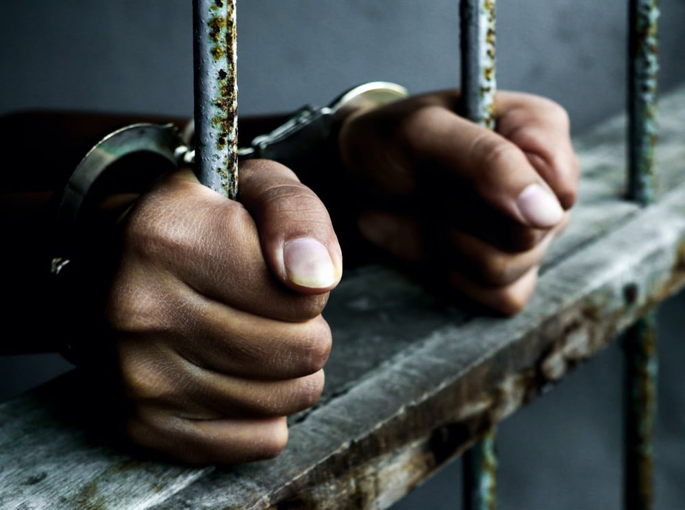 Prisoner holding metal cage in jail no freedom concept